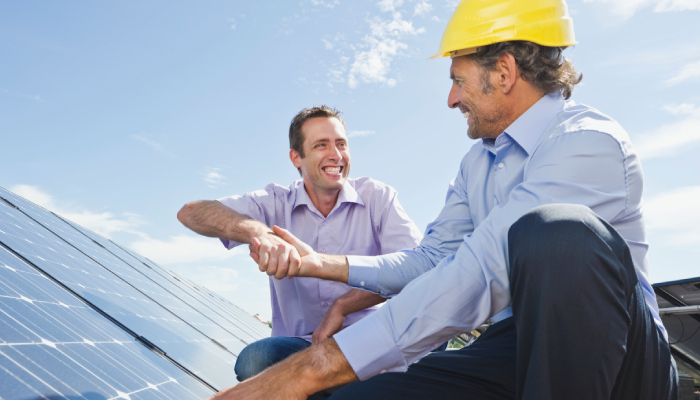 Dos personas instalando panales solares para ser más autosuficientes energéticamente. 
