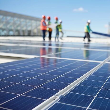 Personas poniendo panales solares en la azotea de un edificio.