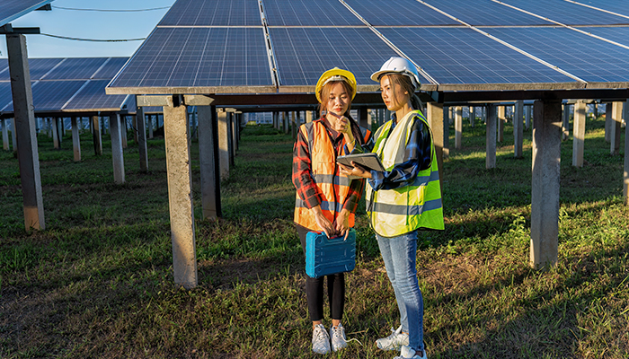 Dos jóvenes instalando un huerto solar 
