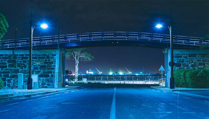 Fotografía de alumbrado público solar en la noche de un puente peatonal.